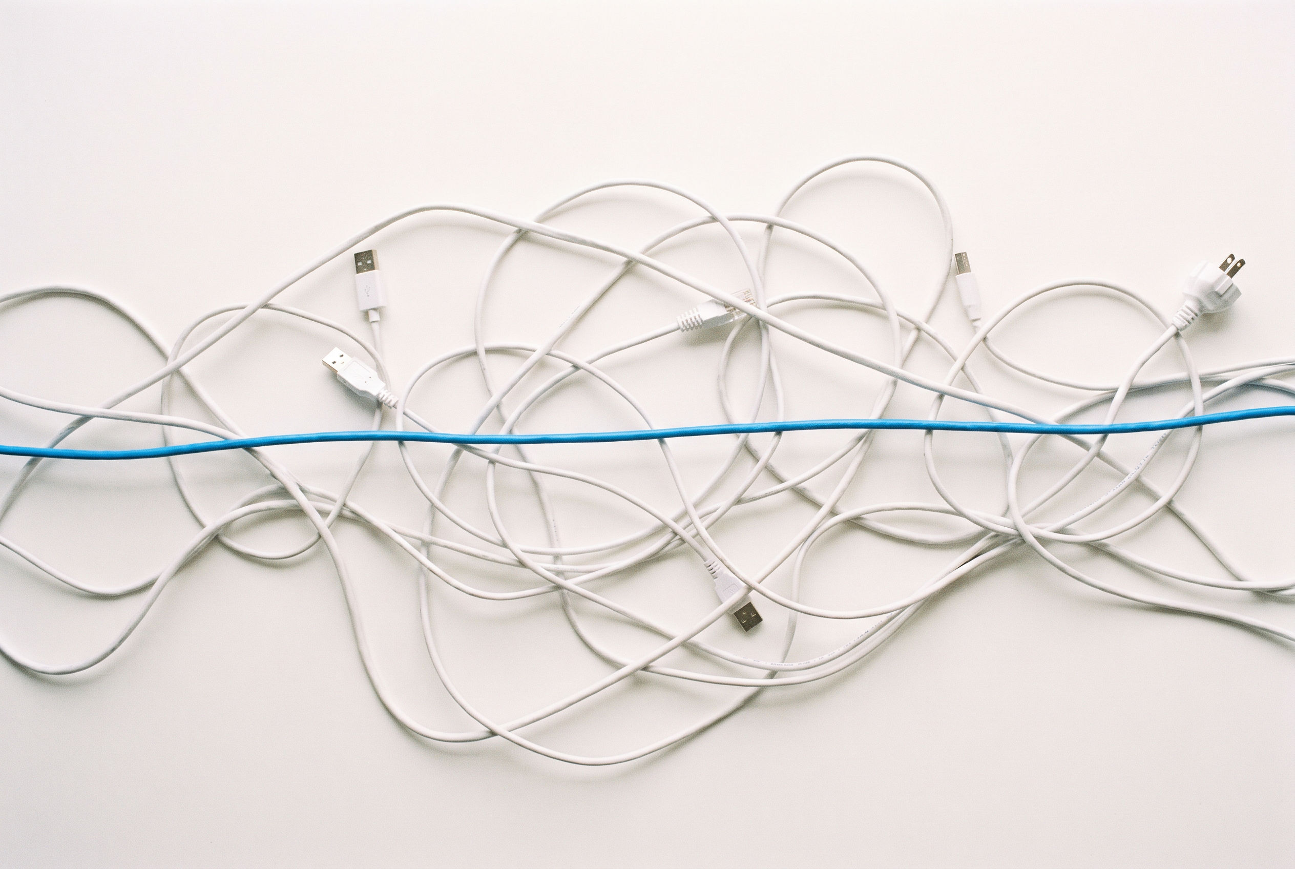 Tangle of white cables with one azure cable running through